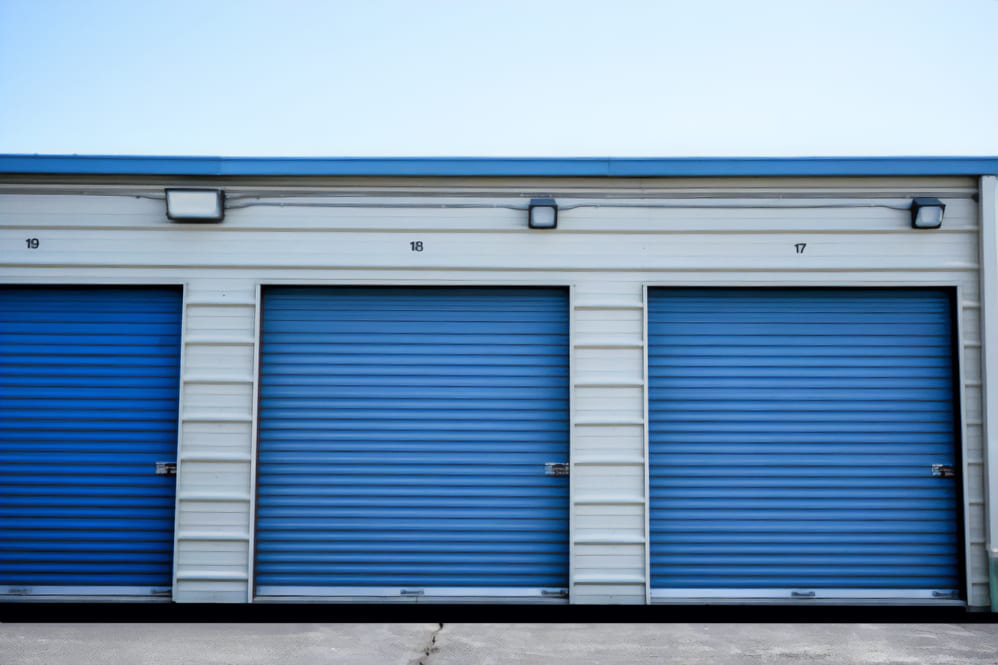 Blue self-storage units labeled 'Keypers Storage' situated in a parking lot.